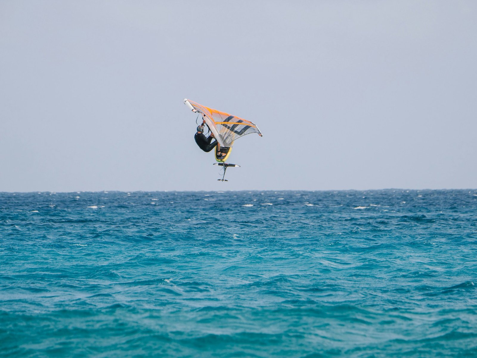 Atleta che esegue acrobazie con il wing foil a Pantelleria durante l’evento SportxEvent con il mare e il vento come sfondo.